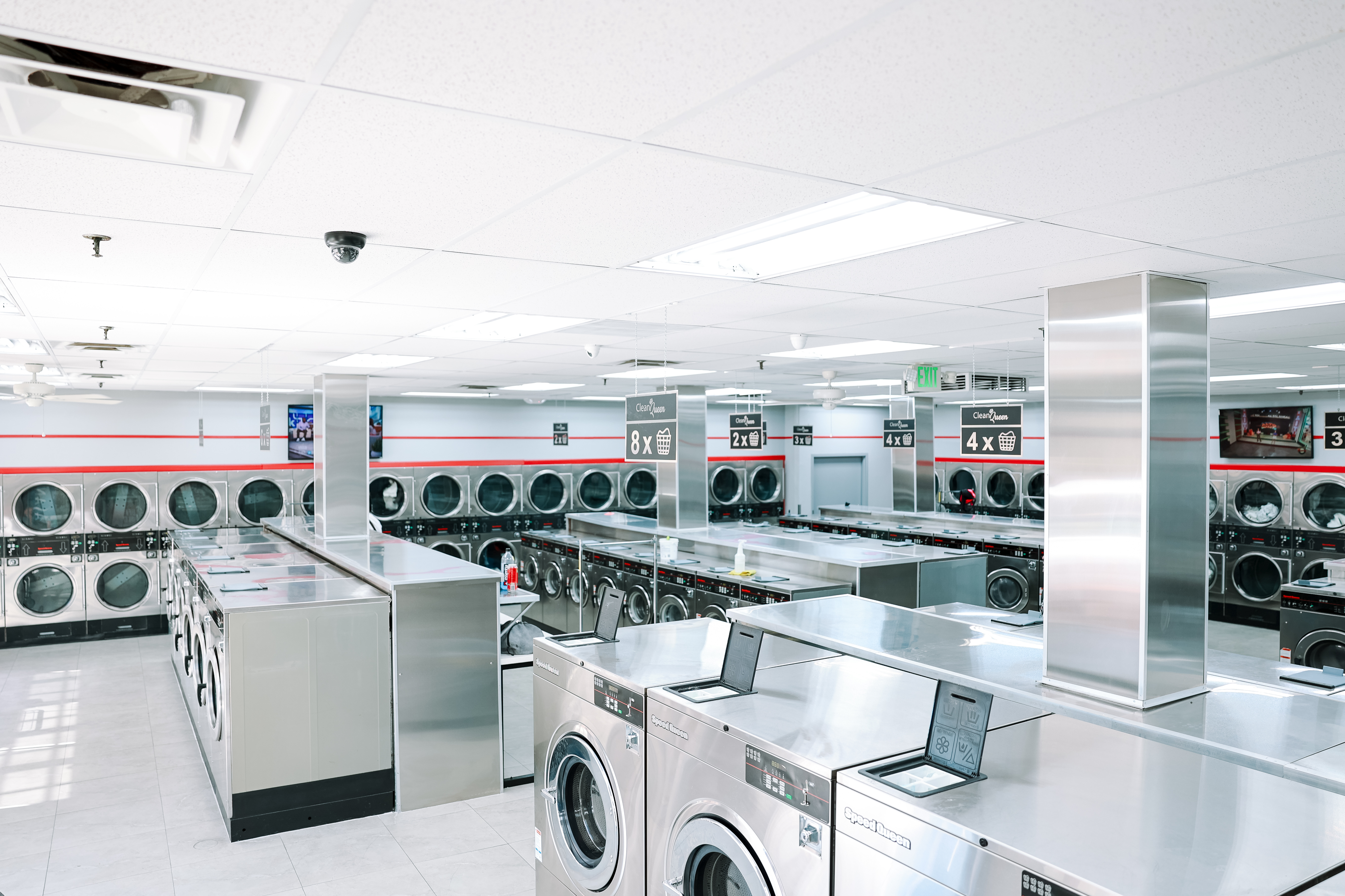 Inside a bright, clean Clean Queen Laundry location with rows of washers